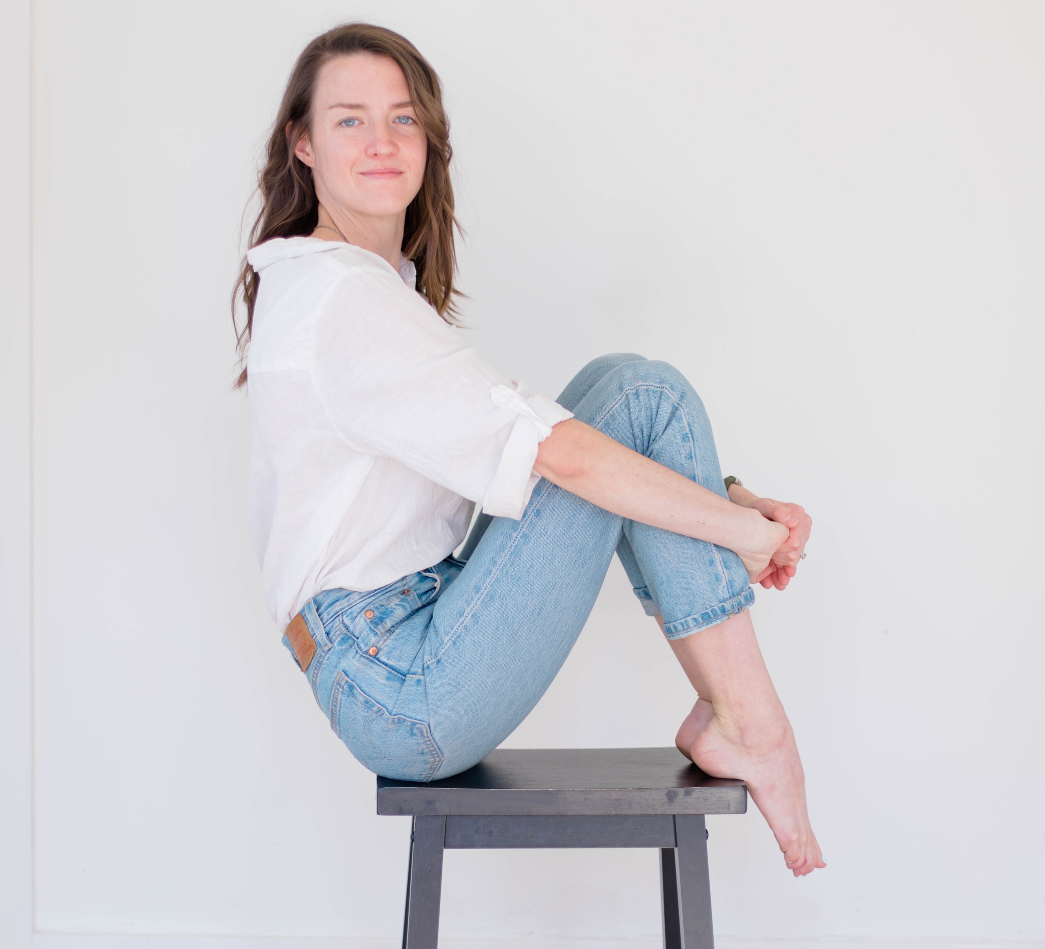 Sheila is an ICF Professional Certified Coach, ready to help Sheila sitting on a stool