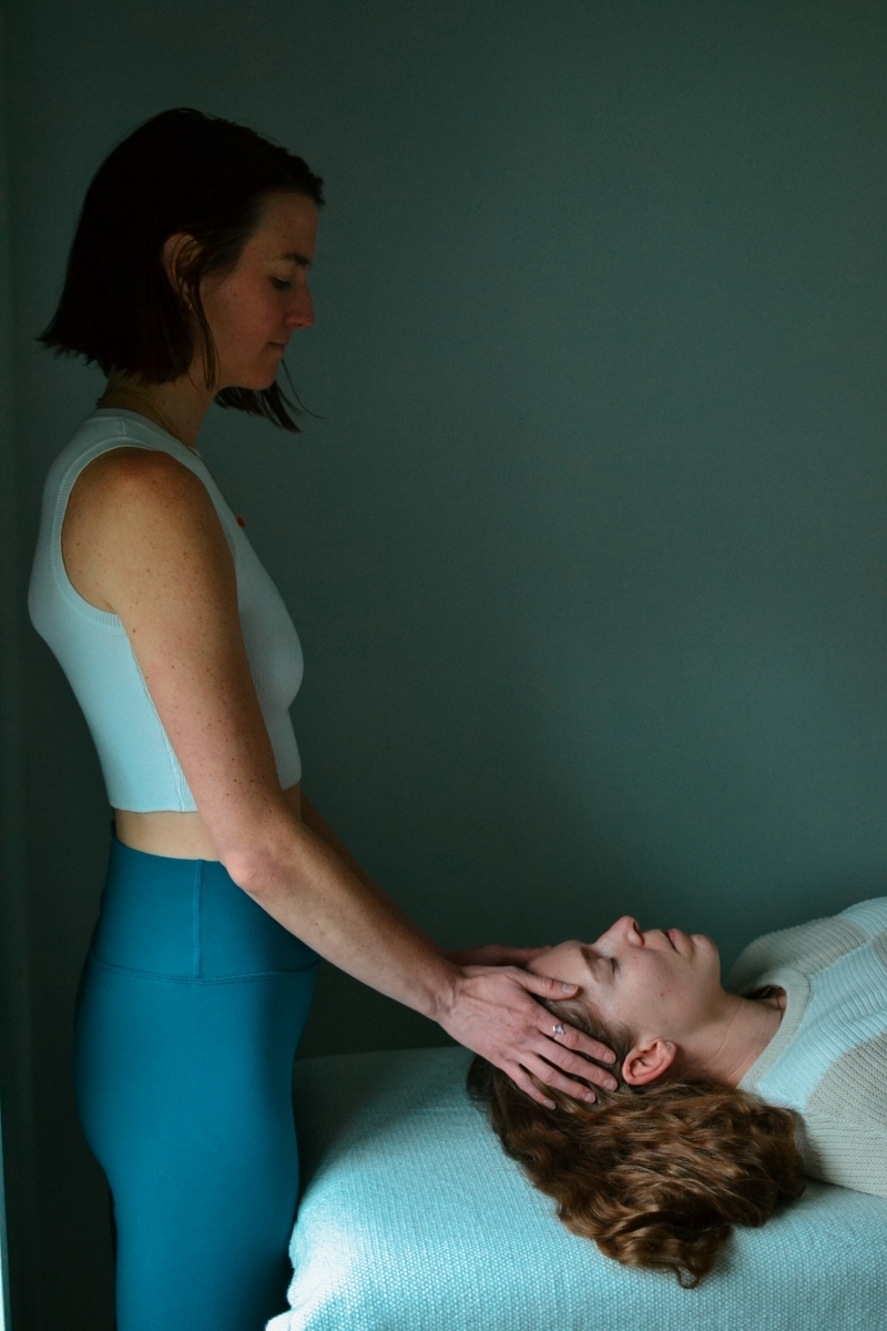 "A zoomed out image of Sheila practicing Reiki on a client"